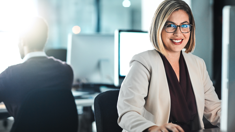 comment rester motivé Unique coaching femme assise devant son écran qui travaille et qui sourit